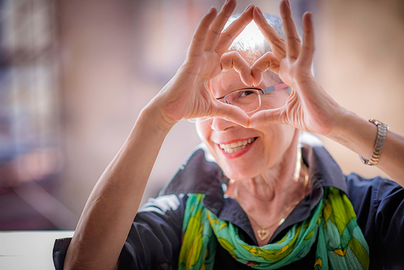 femme âgée faisant un coeur avec ses mains